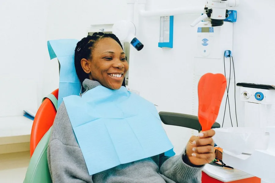 Patient admiring her new smile in the mirror at a Fort Myers cosmetic dentist